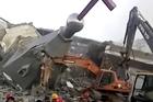 In this image taken from a video shot on Jan. 9, 2018, by China Aid and provided to the Associated Press, people in hard hats stand amid the remains of the Golden Lampstand Church in Linfen in northern China's Shanxi province. (China Aid via AP)