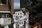 A woman looks towards missing posters stuck on a phone box in front of the remains of Grenfell Tower in London on June 17, 2017. ﻿﻿Police say it will take weeks or longer to recover and identify all the dead in the public housing block fire. (AP Photo/Kirsty Wigglesworth)