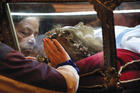 MYSTICAL ENCOUNTER. Worshippers venerate the relics of St. Maria Goretti at St. John Cantius Church in Chicago.