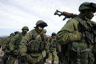 The Russians are coming? Armed men, believed to be Russian servicemen, march outside a Ukrainian military base in Crimea on March 7.