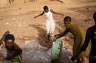 Water is thrown in the street in front of a Vivre dans l’Espérance (Living in Hope) orphanage after a bath in Togo. Photo by Julien Pebrel / Myop