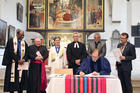 Reformed, Catholic, Lutheran and Methodist leaders look on in St. Mary's City Church in Wittenberg, Germany, as the Rev. Chris Ferguson, World Communion of Reformed Churches general secretary, signs the declaration expressing Reformed churches' support for the Catholic-Lutheran Joint Declaration on the Doctrine of Justification. Photo courtesy of WCRC/Anna Siggelkow