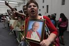 A woman holds up a portrait of St. John Paul II after a Mass at the Basilica of Guadalupe in Mexico City April 27 to celebrate the canonizations of Sts. John Paul and John XXIII. (CNS photo/Henry Romero, Reuters)