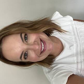 elizabeth newton smiles into the camera wearing a white shirt