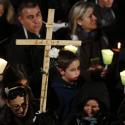 A woman holds a cross during the Way of the Cross presided at by Pope Francis outside the ancient Colosseum in Rome March 25. (CNS photo/Paul Haring)