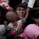 A Rohingya woman holds her infant as she scuffles to receive relief aid Nov. 28 in the Kutupalong refugee camp near Cox's Bazar, Bangladesh. (CNS photo/Susana Vera, Reuters)